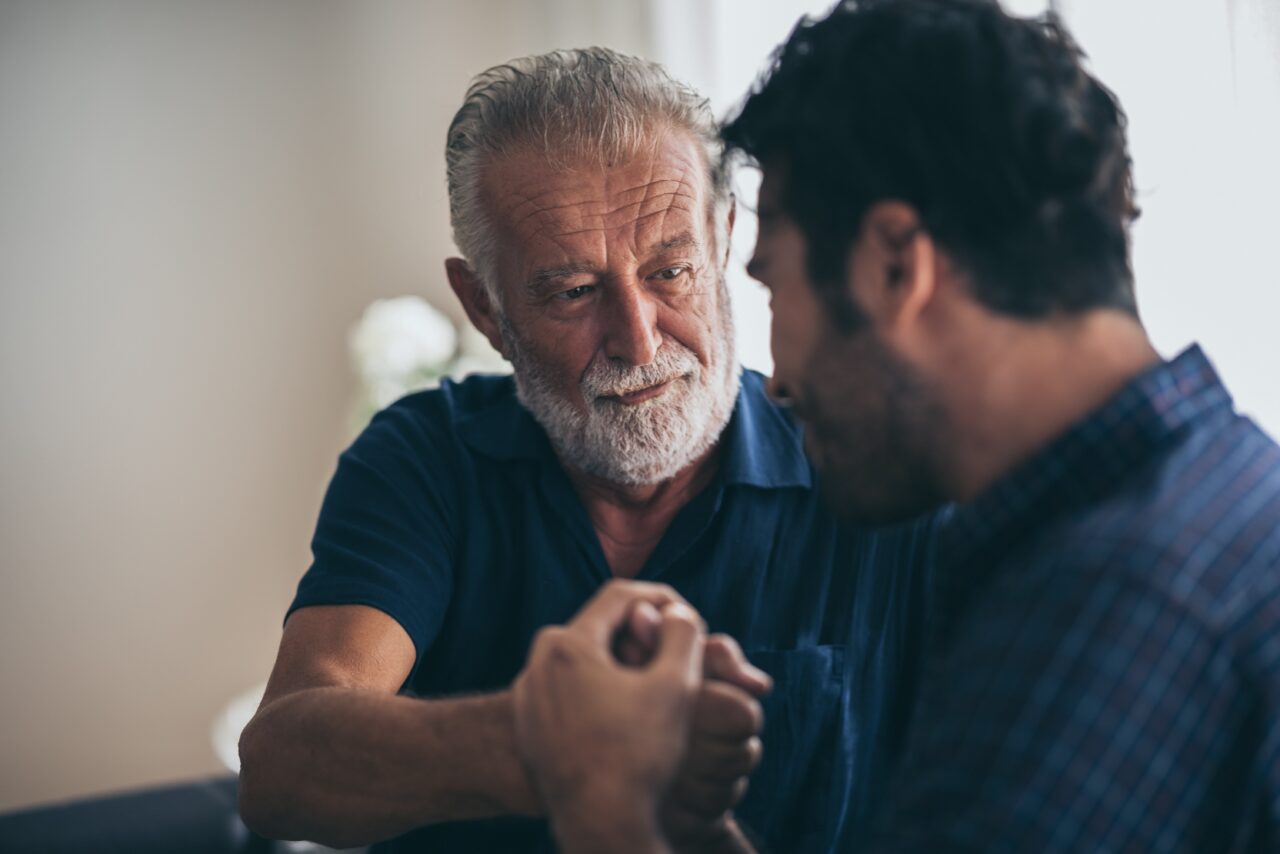 older man talking to son
