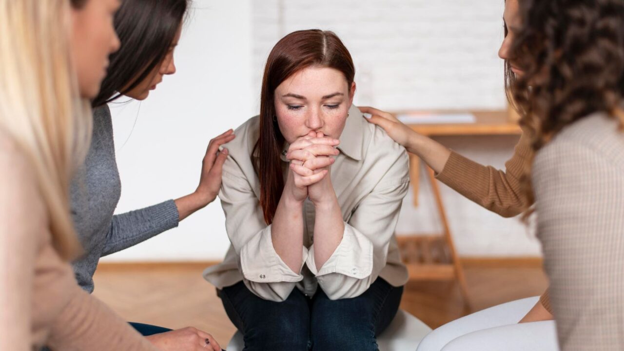 Supportive group comforting a woman at Brenham rehab in Texas.