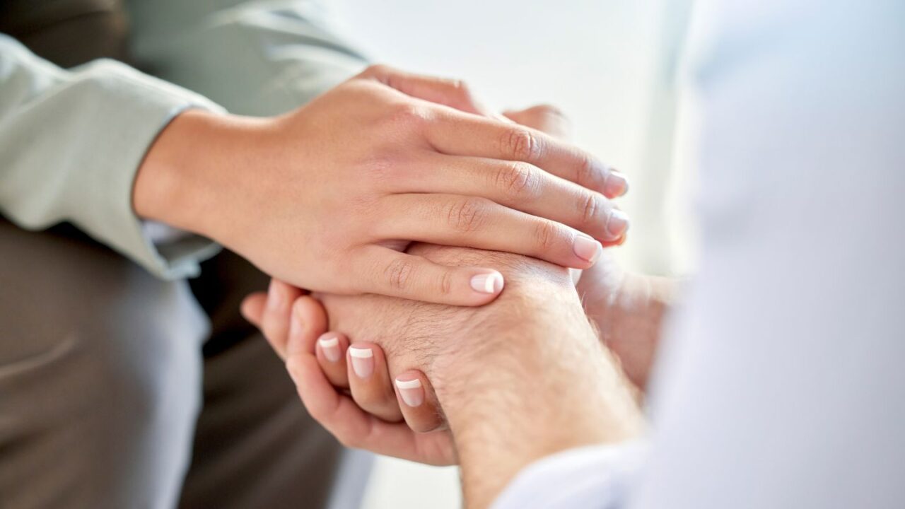 A professional offering support and holding a client's hands at Round Rock rehab in TX. 