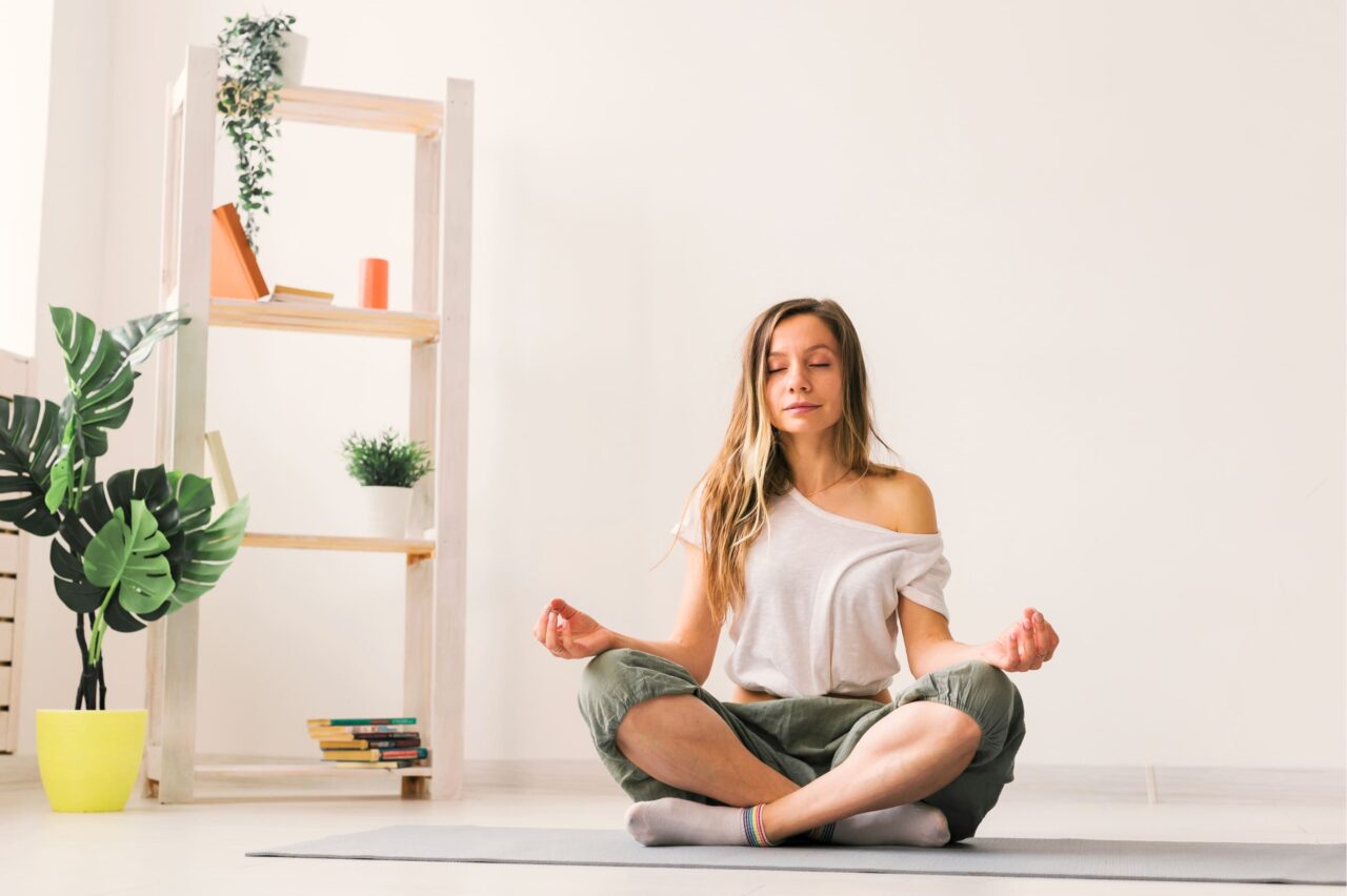 A woman practicing meditation during a wellness program.