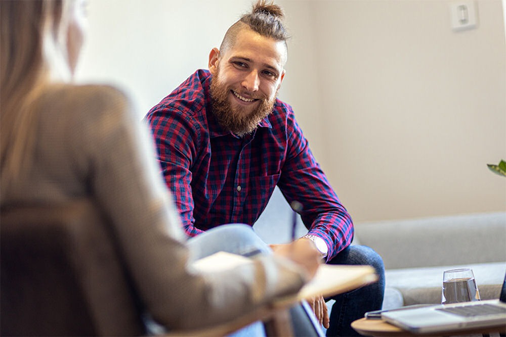 a man smiling in individual therapy