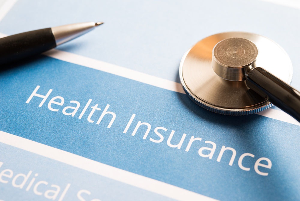 Close-up of stethoscope and pen on a health insurance document, symbolizing access to Cigna drug rehab benefits.