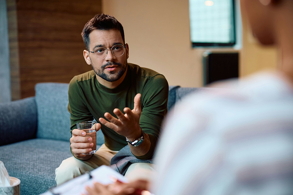 a man holding a glass of water in therapy